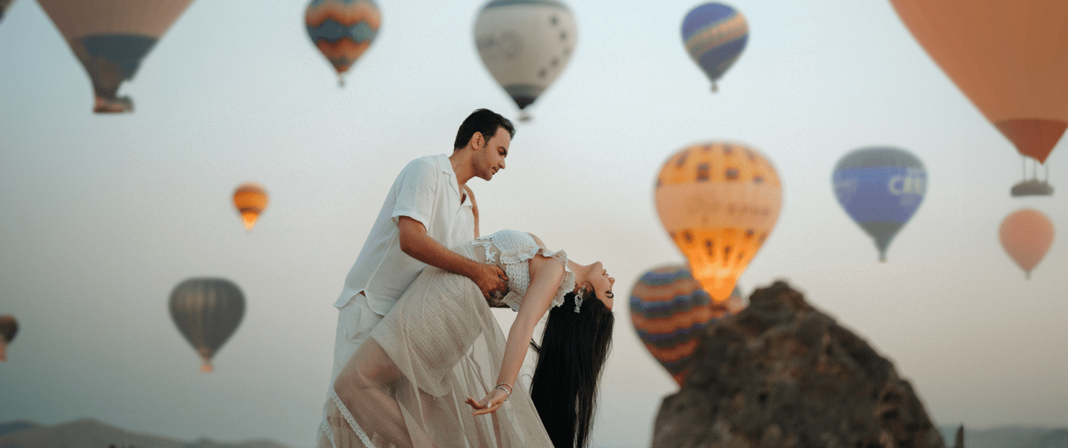 a couple are taking a picture in front of balloons in Cappadocia